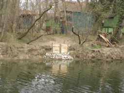 Eine Holzwand am Ufer der Donau als Nistplatz für Eisvögel mit Donau 