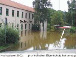 Das Gebäude der Schule bei dem Hochwasser 2002 - Im Hintergrund mit einem kleinen Pfeil gekennzeichnet sieht man den provisorischen Hochwasser Eigenschutz, der damals aber versagte.