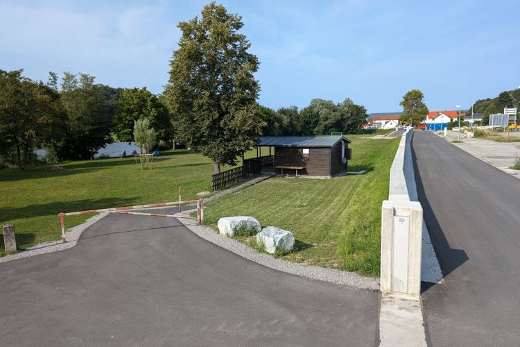 HWS-Mauer mit Öffnung zum Parkplatz am Regen HWS-Mauer mit Öffnung zum Parkplatz am Regen